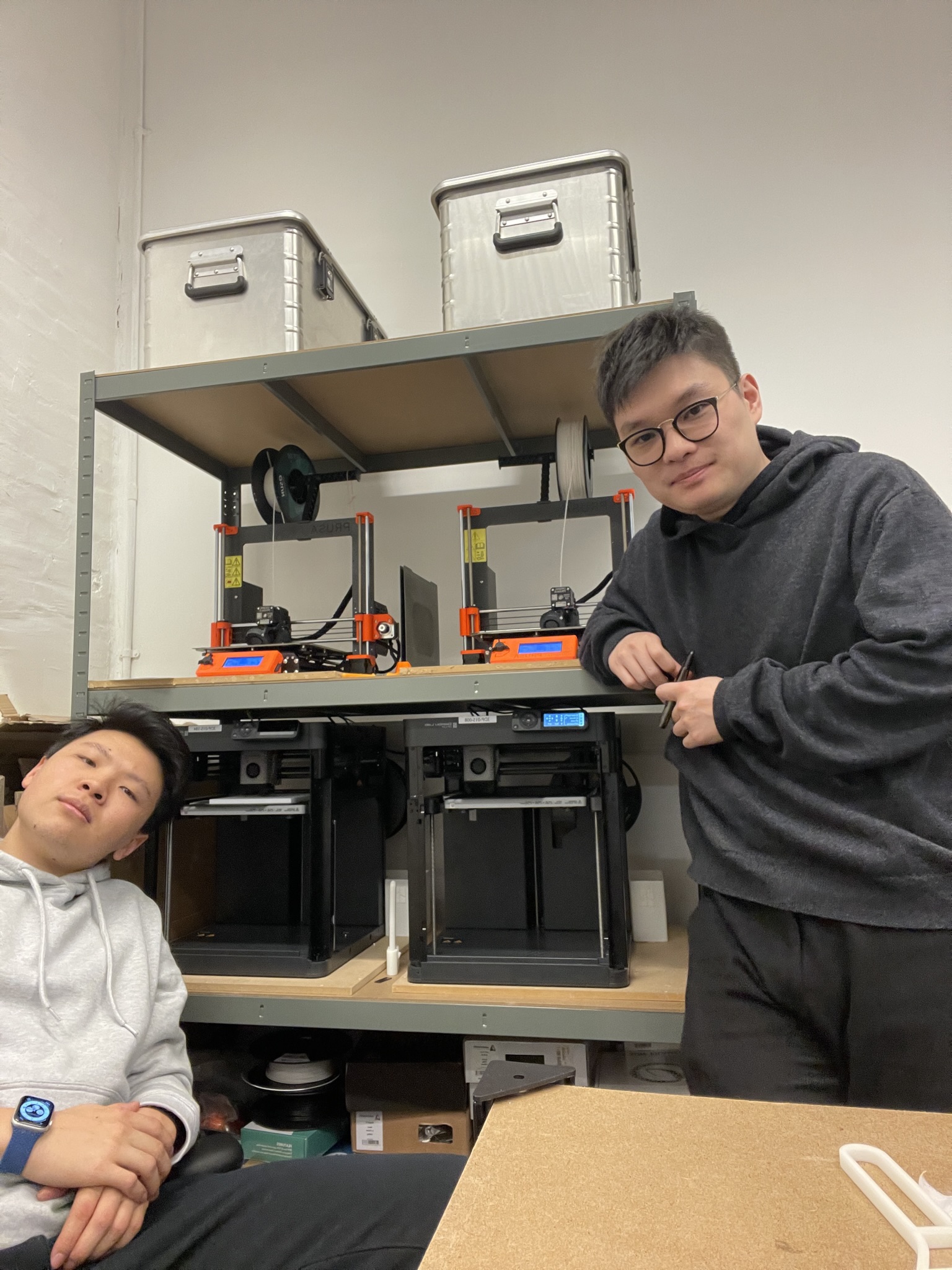 Mel Studio at founding — co-founders standing in front of two FDM machines on a shelving unit, the £5k seed setup