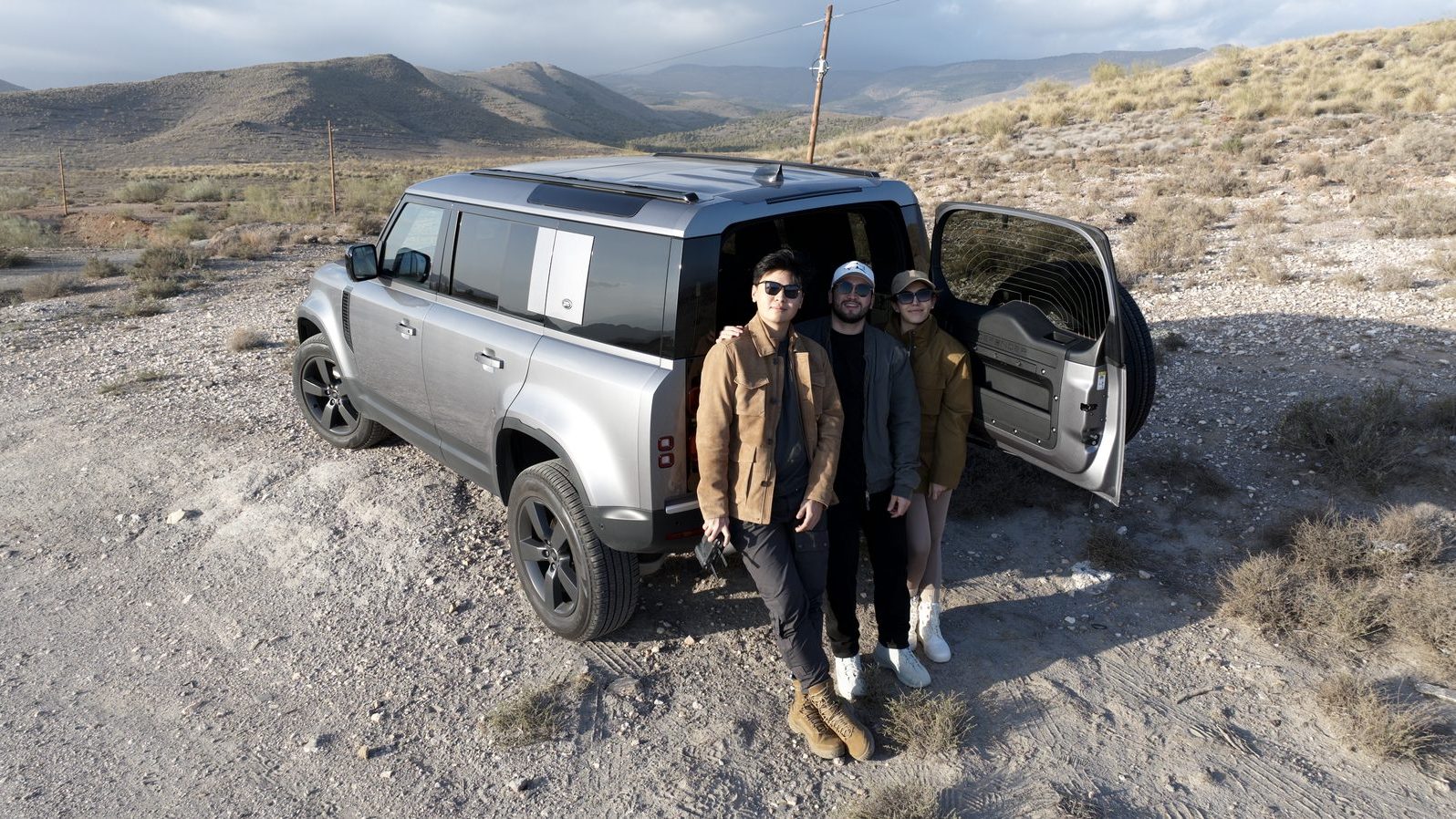 TAG team during the Tabernas site visit — Land Rover Defender parked on a ridge, three researchers in the desert
